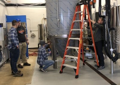 Ignite Brewery Workers setting up newly added brewing equipment